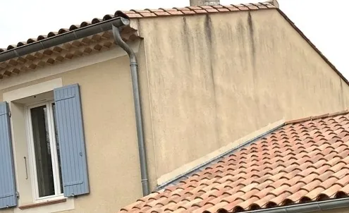 Toiture en tuiles canal neuves au pied d'une maison à volets bleus, couvreur à Bagnols-sur-Cèze